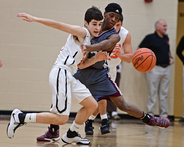 HOWLAND, OHIO - DECEMBER 23, 2016: Jonah Weisman #11 of Howland and Che Trevena #32 of Boardman jocky for position while going after the loose ball during the first half of their game Friday night at Howland High School. DAVID DERMER | THE VINDICATOR
