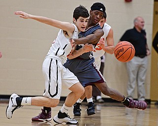HOWLAND, OHIO - DECEMBER 23, 2016: Jonah Weisman #11 of Howland and Che Trevena #32 of Boardman jocky for position while going after the loose ball during the first half of their game Friday night at Howland High School. DAVID DERMER | THE VINDICATOR