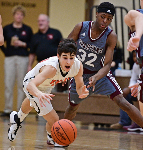 HOWLAND, OHIO - DECEMBER 23, 2016: Jonah Weisman #11 of Howland dives to attempt to gain poession of the loose ball after Che Trevena #32 of Boardman knocked it loose during the first half of their game Friday night at Howland High School. DAVID DERMER | THE VINDICATOR