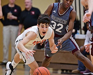 HOWLAND, OHIO - DECEMBER 23, 2016: Jonah Weisman #11 of Howland dives to attempt to gain poession of the loose ball after Che Trevena #32 of Boardman knocked it loose during the first half of their game Friday night at Howland High School. DAVID DERMER | THE VINDICATOR
