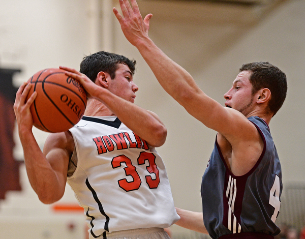 HOWLAND, OHIO - DECEMBER 23, 2016: Kevin Moamis #33 of Howland secures a rebound while being pressured by Mike Melewski #4 of Boardman during the first half of their game Friday night at Howland High School. DAVID DERMER | THE VINDICATOR