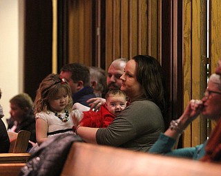 Amber Crawford of Poland holds her daughter Ella Mae(3 mo.) as children participate in Ring-A-Lings at Boardman United Methodist Church in Boardman on Saturday, Dec. 24, 2016...(Nikos Frazier | The Vindicator)..