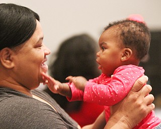 William D. Lewis the vindicator Sheila Taylor share a moment with her great niece Nia Johnson, 7 months, during first night of Kwanza celebration Monday at New Bethel Baptist Church in Youngstown. They are from Youngstown.