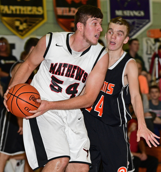 VIENNA, OHIO - DECEMBER 26, 2016: Tyler Koeppen #54 of Mathews looks to pass the ball after grabbing a rebound away from Robby Ambrose #14 of Mineral Ridge during the first half of their game Monday night at Mathews High School. DAVID DERMER | THE VINDICATOR