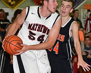 VIENNA, OHIO - DECEMBER 26, 2016: Tyler Koeppen #54 of Mathews looks to pass the ball after grabbing a rebound away from Robby Ambrose #14 of Mineral Ridge during the first half of their game Monday night at Mathews High School. DAVID DERMER | THE VINDICATOR