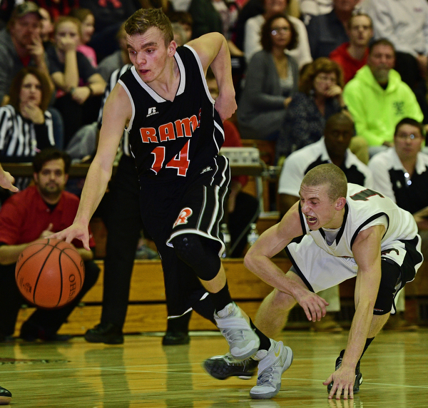 VIENNA, OHIO - DECEMBER 26, 2016: Robby Ambrose #14 of Mineral Ridge dribbles away from a diving Kenny Wallace #11 of Mathews during the first half of their game Monday night at Mathews High School. DAVID DERMER | THE VINDICATOR