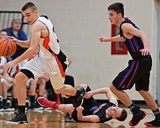 NEW Middletown, OHIO - DECEMBER 28, 2016: Jake Ford #30 of Springfield dribbles away from Garrett Behner #4, bottom, and Nicholas Frank #0, right, of Lordstown during the first half of their game Wednesday night at Springfield High School. DAVID DERMER | THE VINDICATOR