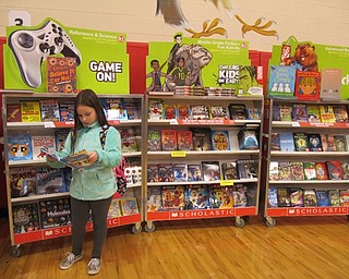 Neighbors | Alexis Bartolomucci.One of the students from Austintown Intermediate School looks through one of the books during the Scholastic Book Fair on Nov. 15.