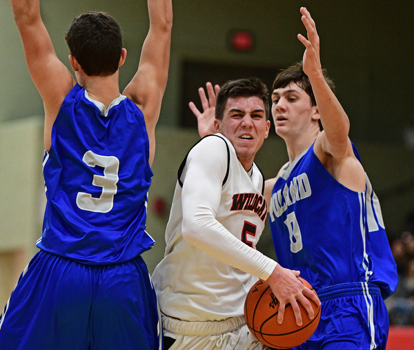 STRUTHERS, OHIO - DECEMBER 30, 2016: Andrew Carbon #5 of Struthers splits the defense of Braeden O'Shaungnessy #3 and Daniel Kramer #10 of Poland during the second half of their game Friday night at Struthers High School. DAVID DERMER | THE VINDICATOR