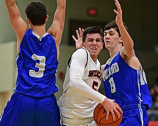 STRUTHERS, OHIO - DECEMBER 30, 2016: Andrew Carbon #5 of Struthers splits the defense of Braeden O'Shaungnessy #3 and Daniel Kramer #10 of Poland during the second half of their game Friday night at Struthers High School. DAVID DERMER | THE VINDICATOR