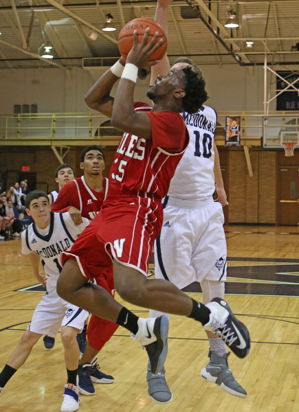 Tyreece Williams (35) of Niles goes up for a shot while being defended by McDonald's Evan Magill (10) during the second quarter of Friday nights matchup at McDonald High School.  Dustin Livesay  |  The Vindicator  12/30/16  McDonald.