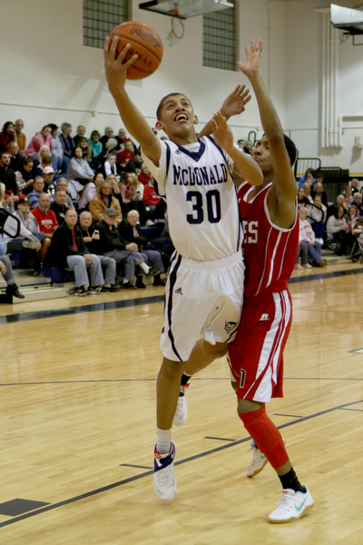 Braedon Poole (30) puts up a layup while being defended by Donald Daniel (24) of Niles during the third quarter of Friday nights matchup against Niles High School at McDonald High School.  Dustin Livesay  |  The Vindicator  12/30/16  McDonald.