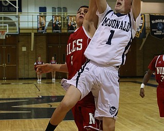 Zach Rasile (1) of McDonald puts up a jump shot while being defended by Cyler Kane Johnson (4) during the third quarter of Friday nights matchup at McDonald High School.  Dustin Livesay  |  The Vindicator  12/30/16  McDonald.