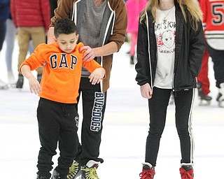 Jeremy Demarco(15)(center) helps Jihad Niser(7) ice skate while talking with Kaleigh Calvey(14) during First Night Youngstown at the the Covelli Centre in Youngstown on Saturday, Dec. 31, 2016...(Nikos Frazier | The Vindicator)..