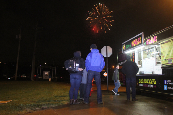 A family watches fireworks off the Market St. Bridge on Front Street in Youngstown on Saturday, Dec. 31, 2016...(Nikos Frazier | The Vindicator)..