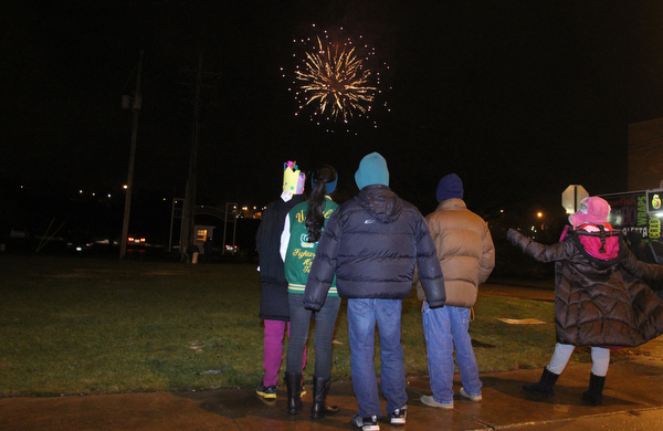 The Huang Family watches fireworks off the Market St. Bridge on Front Street in Youngstown on Saturday, Dec. 31, 2016...(Nikos Frazier | The Vindicator)..