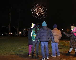 The Huang Family watches fireworks off the Market St. Bridge on Front Street in Youngstown on Saturday, Dec. 31, 2016...(Nikos Frazier | The Vindicator)..