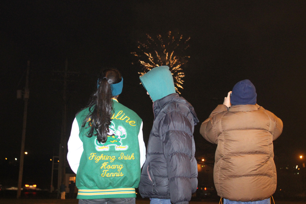 Son Huang(16((center) turns to his cousin, Vy Huang(16)(left) as they watch fireworks off the Market St. Bridge with Son's uncle, Binh Huang of Youngstown on Front Street in Youngstown on Saturday, Dec. 31, 2016...(Nikos Frazier | The Vindicator)..