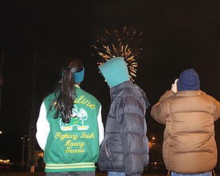 Son Huang(16((center) turns to his cousin, Vy Huang(16)(left) as they watch fireworks off the Market St. Bridge with Son's uncle, Binh Huang of Youngstown on Front Street in Youngstown on Saturday, Dec. 31, 2016...(Nikos Frazier | The Vindicator)..
