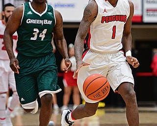 YOUNGSTOWN, OHIO - DECEMBER 31, 2016: Braun Hartfield dribbles up court ahead of Charles Cooper #34 of Green Bay during the first half of their game Saturday afternoon at Beeghly Center. DAVID DERMER | THE VINDICATOR
