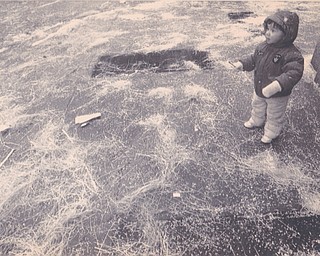 YSU parade surrounded by confetti is Zachary morse, 2, of Austintown. He was watching the parade on Boardman st. He is the son of jack and janice Morice. 1/17/1991