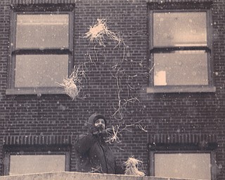 YSU Pareade- Kenneth Richards of Youngstown who works as a heating and air conditioning superviosr for Ohio One Corp. Throws confetti off the roof of the Ohio One Building. 1/17/1991