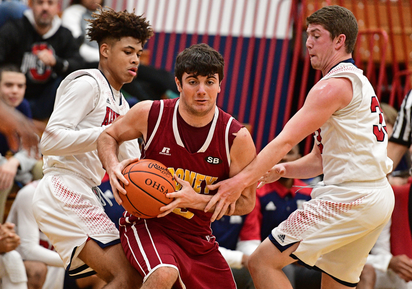 WARREN, OHIO - JANUARY 3, 2017: Pete Haas #5 of Mooney dribbles between Hyland Burton #0 and Justin Bofenkamp #33 of JFK during the first half of their game Tuesday night at John F. Kennedy High School. DAVID DERMER | THE VINDICATOR