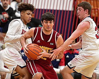 WARREN, OHIO - JANUARY 3, 2017: Pete Haas #5 of Mooney dribbles between Hyland Burton #0 and Justin Bofenkamp #33 of JFK during the first half of their game Tuesday night at John F. Kennedy High School. DAVID DERMER | THE VINDICATOR