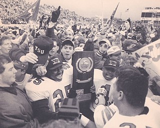 YSU RUNNING BACKS TAMRON SMITH (LEFT) AND DARNELL CLARK WITH THE NATION CHAMPIONSHIP TROPHY IN HAND CELEBRATE WITH THE PENGUIN FANS FOLLOWING THE TEAMS 17-5 VICTORY OVER MARSHALL.  Dec. 18, 1993 Bob DeMay | The Vindicator File Photo
