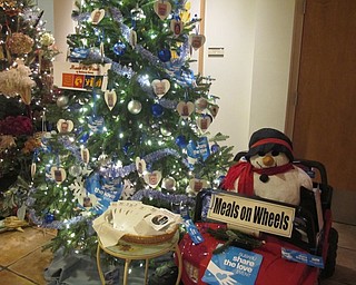 Neighbors | Alexis Bartolomucci.The Meals on Wheels tree at Fellows Riverside Gardens was decorated with photos of drivers and members of the Meals on Wheels team.