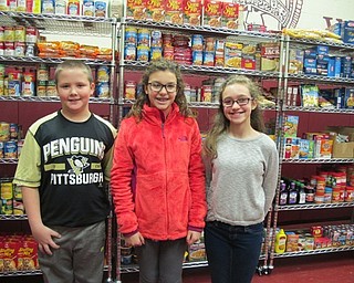 Neighbors | Alexis Bartolomucci.Sixth-grade students stood in front of the food they brought in for the food pantry at Boardman Center Intermediate School on Nov. 29. Pictured are, from left, Danny Enright, Sarah Congemi and Lilly Snyder.