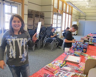 Neighbors | Alexis Bartolomucci.Fourth-grade student Stella Pompeo held up one of the gifts she picked out during the Santa's Workshop at Dobbins Elementary.