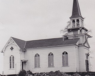 Steeple Raising - The steeple of historic St. James Episcopal Church of Boardman, from the structure since Jan. 11 when they were moved from Market Street to Boardman Township Park, were reunited this morning and the cross replaced on the steeple. Watching were, left to right, Mrs. Robert Pollock, church member and a member of the Boardman Historical Society which collaborated to have the landmark moved rather than razed, and Dr. Norman M. Parr, executive director of the Mahoning Valley Association of Churches.