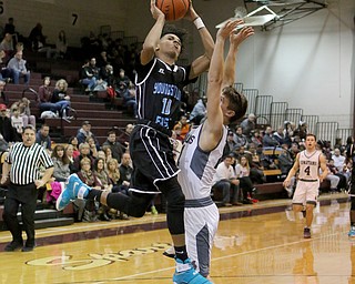 Terrell Weaver (10) of Youngstown East goes up for a layup while being defended by Boardman's Sebastian Heinonen (21) during the first half of Friday nights matchup at Boardman High School.  Dustin Livesay  | The Vindicator  1/6/17   Boardman