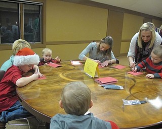 Neighbors | Alexis Bartolomucci.Children at the Supper with Santa event on Dec. 8 at Boardman Park worked on the scratch off tree craft.