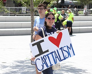 Nikos Frazier | The Vindicator..A woman holds a "I heart capitalism" sign in Cleveland's Public Square during the first day of the Republican National Convention.