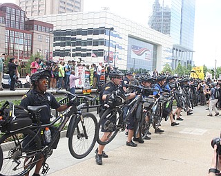Nikos Frazier | The Vindicator..Police officers lift up their bikes and push forward in an effort to divide a small group of conservative protestors from larger group of Black Lives Matters protestors in The mall in Cleveland during the first day of the Republican National Convention.