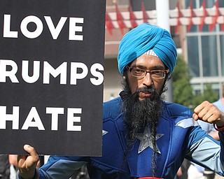 Nikos Frazier | The Vindicator..A man in a Captain America Costume holds a "Love Trumps Hate" sign in Perk Plaza during the first day of the Republican National Convention.