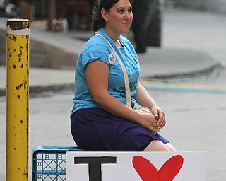 Nikos Frazier | The Vindicator.. A woman with a "I heart Capitalism" sign poses for a photograph in an alleyway off of E. 4th St.