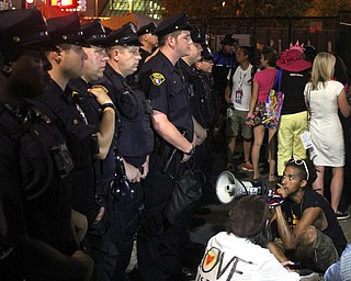 Nikos Frazier | The Vindicator..Protestors sit down in front of a line of Cleveland Police during the fourth and final day of the Republican National Convention.
