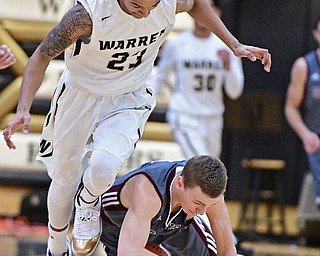 WARREN, OHIO - JANUARY 13, 2017: Holden Lipke #3 of Boardman falls to the court while protecting the basketball while being pressured by Chris Hughes #23 of Harding during the first half of their game Friday night at Warren Harding High School. DAVID DERMER | THE VINDICATOR