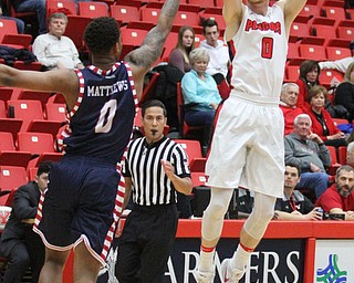 Youngstown State senior forward Matt Dolan(0) goes for three as University of Illinois at Chicago sophomore guard Dominique Matthews(0) attempts to block his shot during the first half as the Youngstown State Penguins take on the University of Illinois at Chicago Flames at the Beeghly Center in Youngstown on Saturday, Jan. 14, 2017. UIC won, 92-89 in Overtime...(Nikos Frazier | The Vindicator)..