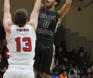 Harding senior Tiryn Frank(0) goes for the jump shot as Canfield senior forward Jared Clark(13) attempts to block during the first quarter as Warren G. Harding High School takes on Canfield High School at the Canfield High School Gymnasium in Canfield on Tuesday, Jan. 17, 2017. Harding won, 80-62...(Nikos Frazier | The Vindicator)..