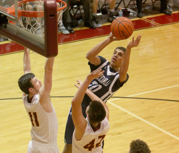 Brayden Poole (30) of McDonald goes up for a shot while being defended by South RangesMike Cunningham (42) and Daniel Ritter (11) during the first half of Tuesday nights matchup at South Range High School.  Dustin Livesay  |  The Vindicator  1/17/17  South Range