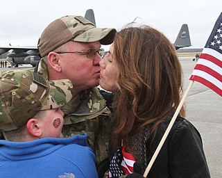 William D. Lewis The Vindicator USAF reserve Sgt. Rich Lawton of Canfield kisses his wife Lisa Lawton, at left is his grandson Dominic Mullins, 10, after returning from deployment with members of US Air Force reserve unit at YARS  Jan. 18, 2017.