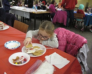 Neighbors | Alexis Bartolomucci.Rylynn used frosting to glue her graham crackers to a milk carton to create a holiday house at the Poland library on Dec. 20.