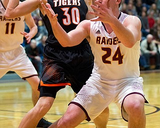 MICHAEL G TAYLOR | THE VINDICATOR- 01-20-17 - Basketball -2nd qtr, South Range's #24 Taymer Graham looses control of the ball as Springfield's #30 Jake Ford defends. New Middletown Springfield Tigers vs South Range Raiders at South Range High School in South Range, OH