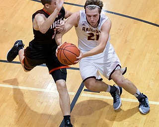 MICHAEL G TAYLOR | THE VINDICATOR- 01-20-17 - Basketball - 3rd qtr, South Range's #21 Brandon Youngs drives to the hoop against Springfield's #30 Jake Ford. New Middletown Springfield Tigers vs South Range Raiders at South Range High School in South Range, OH