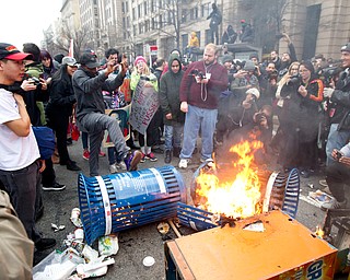Protesters burn trash cans during the demonstration downtown Washington, Friday, Jan. 20, 2017, during the inauguration of President Donald Trump. ( AP Photo/Jose Luis Magana)