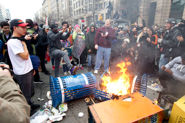 Protesters burn trash cans during the demonstration downtown Washington, Friday, Jan. 20, 2017, during the inauguration of President Donald Trump. ( AP Photo/Jose Luis Magana)
